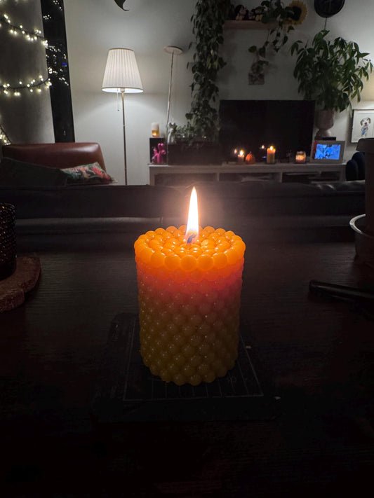 Lit beeswax candle with cotton wick
