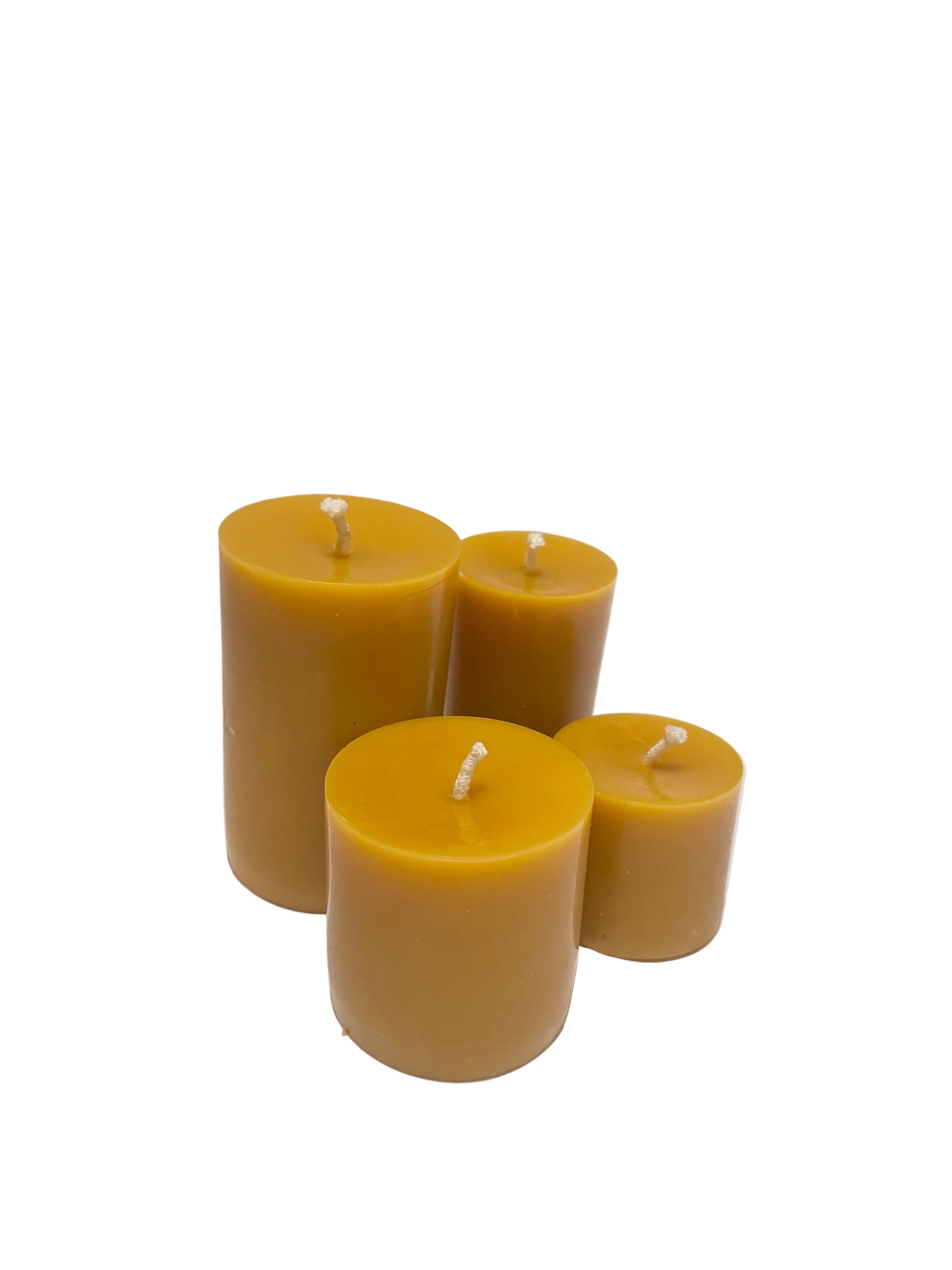 Four yellow beeswax pillar candles on a white surface 