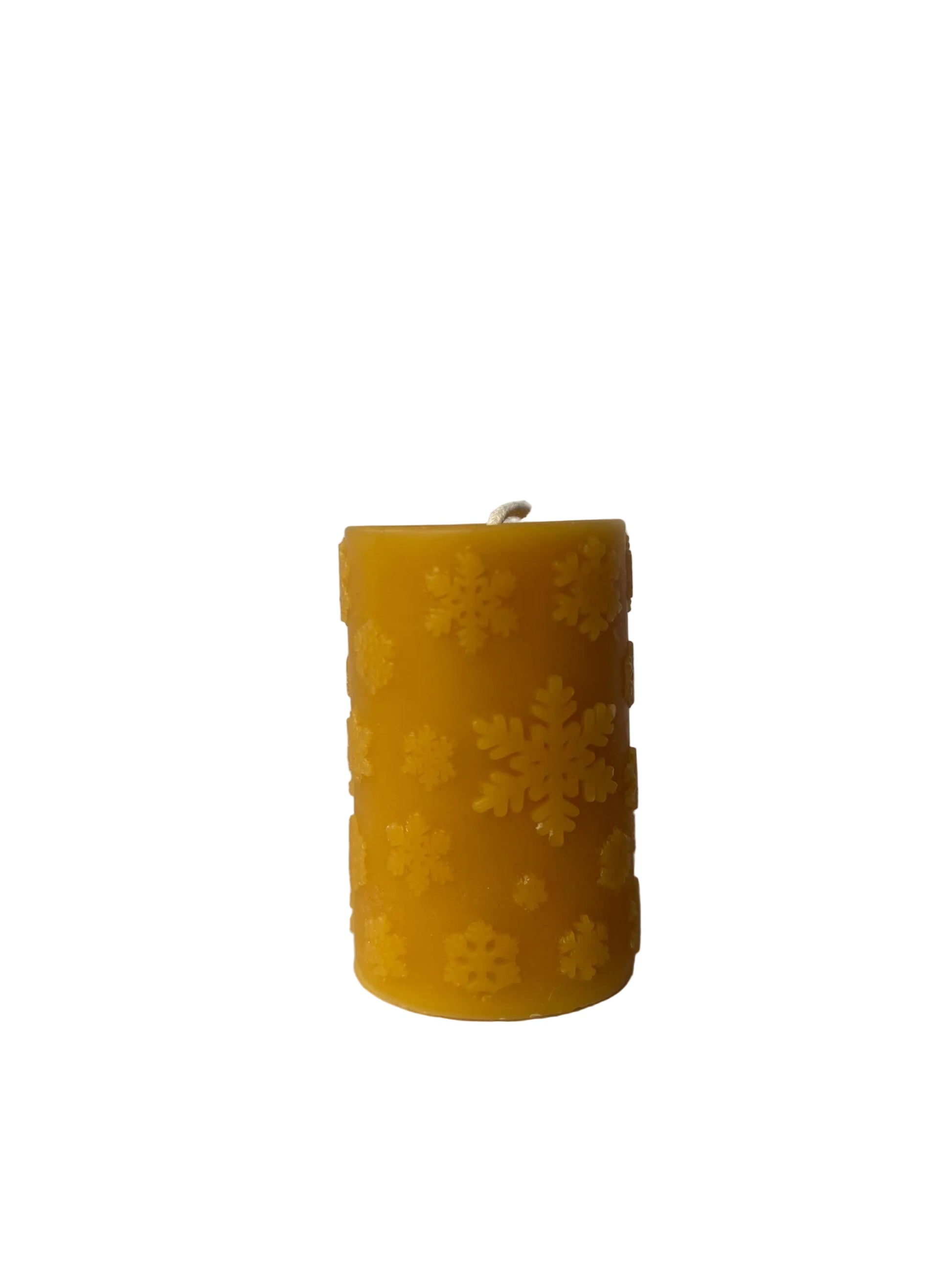 pillar candle with snowflakes  shaped candle made of beeswax on a white background