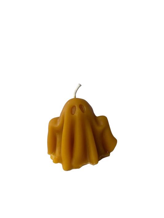 Yellow ghost-shaped candle made of beeswax on a white background